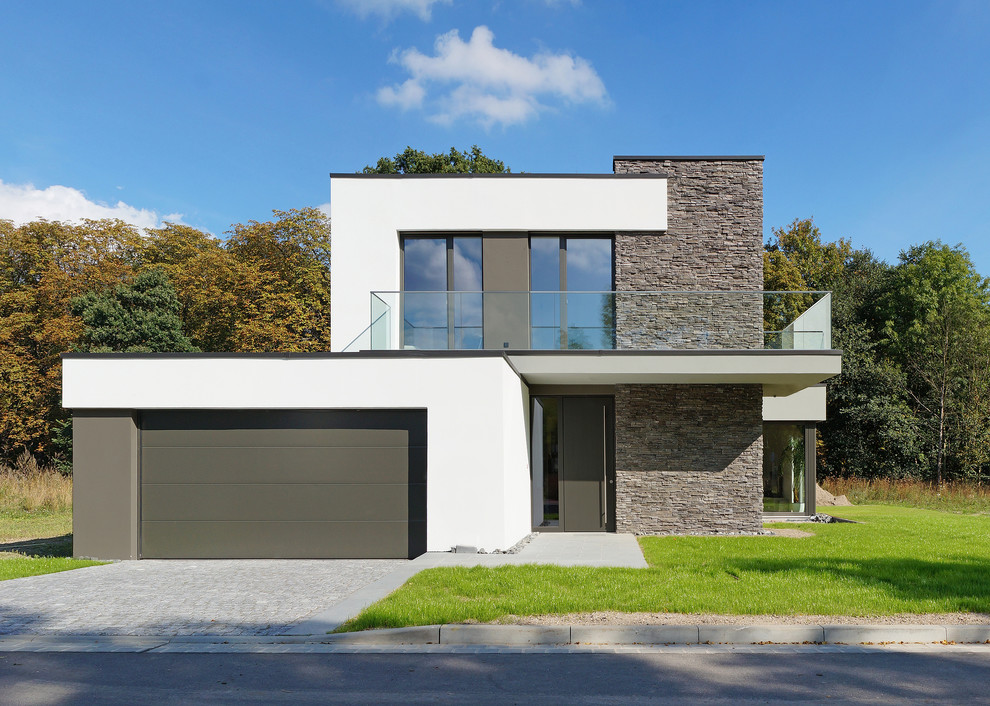 Photo of a medium sized modern two floor house exterior in Leipzig with a flat roof and mixed cladding.