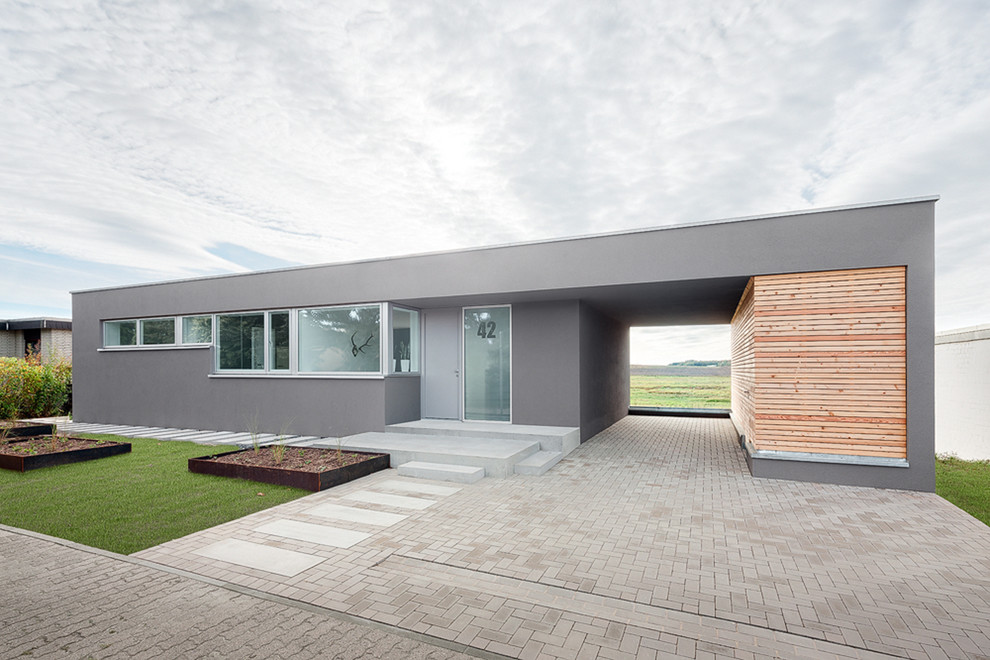 Idée de décoration pour une façade de maison grise minimaliste de plain-pied et de taille moyenne avec un toit plat.