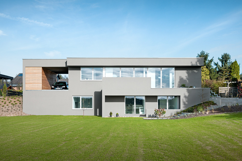 Modelo de fachada gris moderna grande de dos plantas con tejado plano