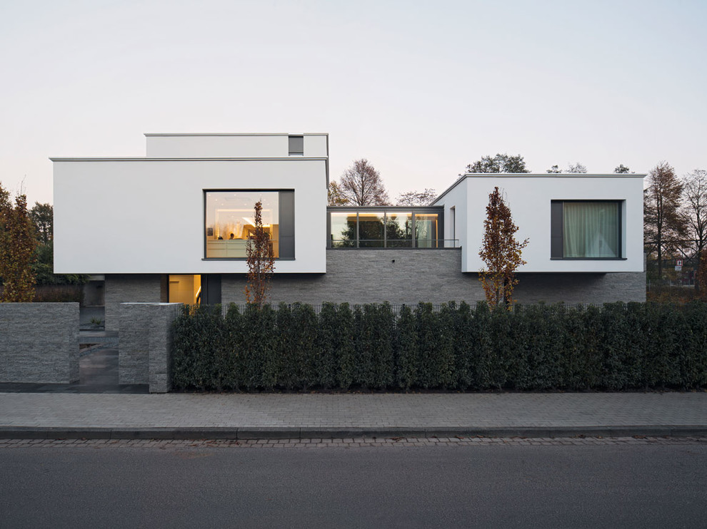 Inspiration pour une façade de maison multicolore minimaliste de taille moyenne et à un étage avec un toit plat et un revêtement mixte.