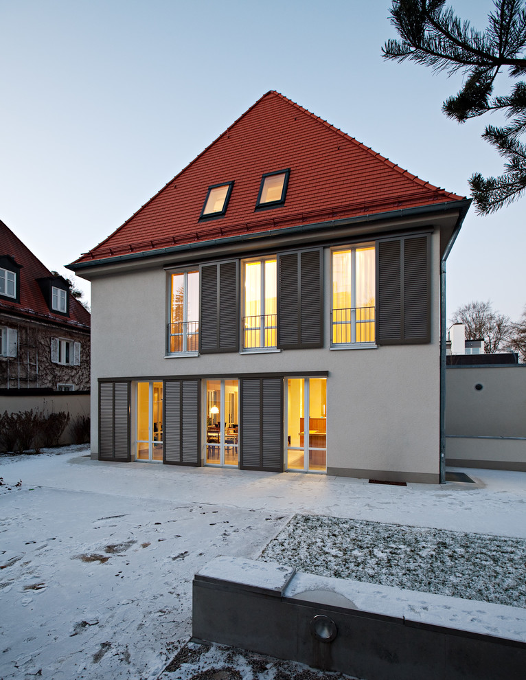 Design ideas for a medium sized and beige classic house exterior in Munich with three floors and a hip roof.