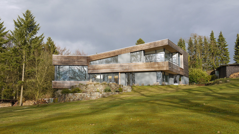 Inspiration pour une grande façade de maison marron design en bois à un étage avec un toit en appentis.