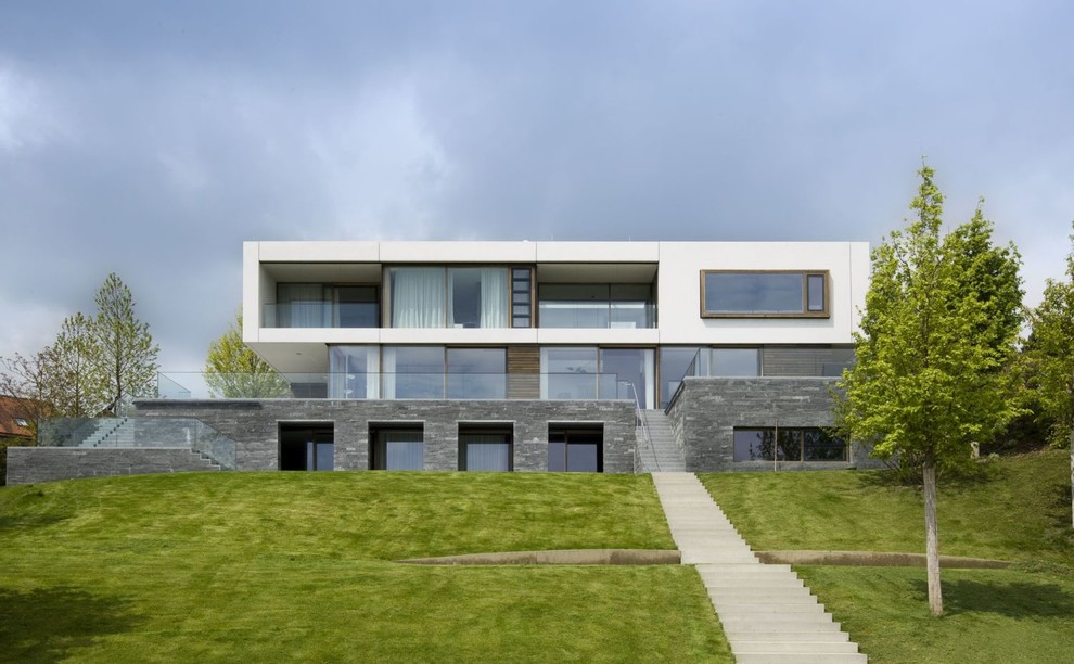 Zweistöckiges Modernes Haus mit Steinfassade, grauer Fassadenfarbe und Flachdach in München