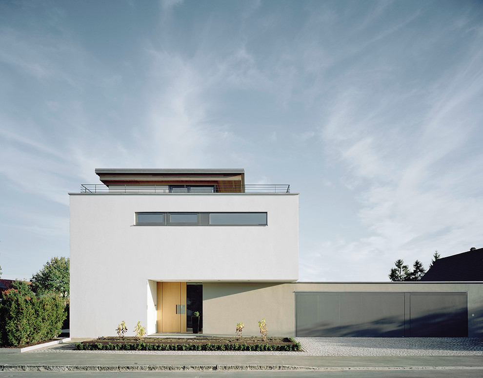 Großes, Dreistöckiges Modernes Haus mit weißer Fassadenfarbe und Flachdach in München