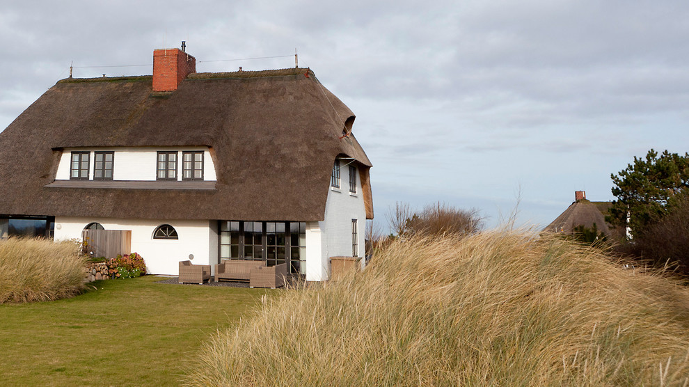 Ejemplo de fachada blanca de estilo de casa de campo de tamaño medio de tres plantas con tejado a la holandesa