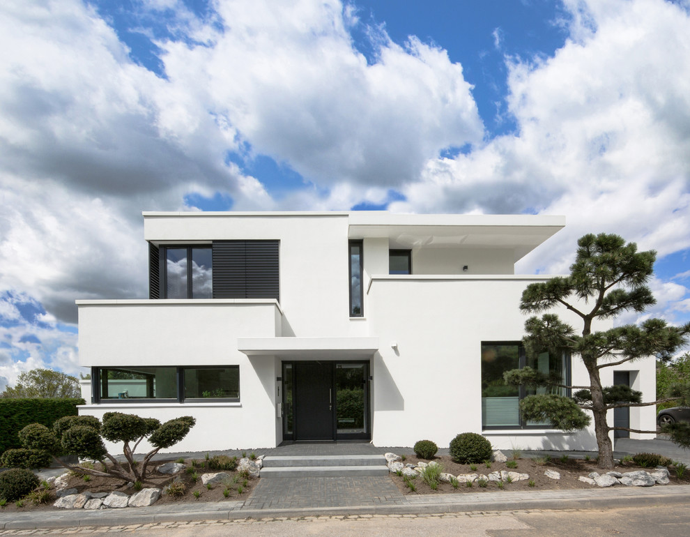 Cette image montre une grande façade de maison blanche design à un étage avec un toit plat.