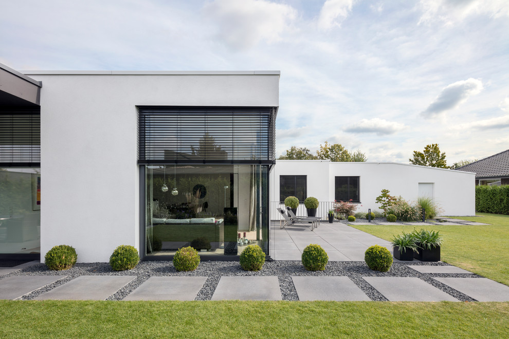 Источник вдохновения для домашнего уюта: одноэтажный, белый дом в стиле модернизм с облицовкой из цементной штукатурки и плоской крышей