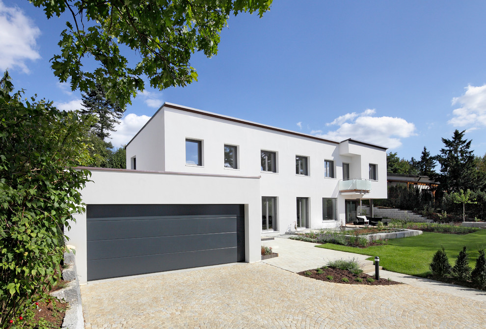 Diseño de fachada blanca moderna grande de dos plantas con revestimiento de estuco y tejado plano