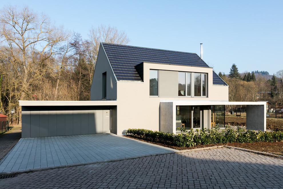Kleines, Zweistöckiges Modernes Einfamilienhaus mit Betonfassade, grauer Fassadenfarbe und Satteldach in Stuttgart