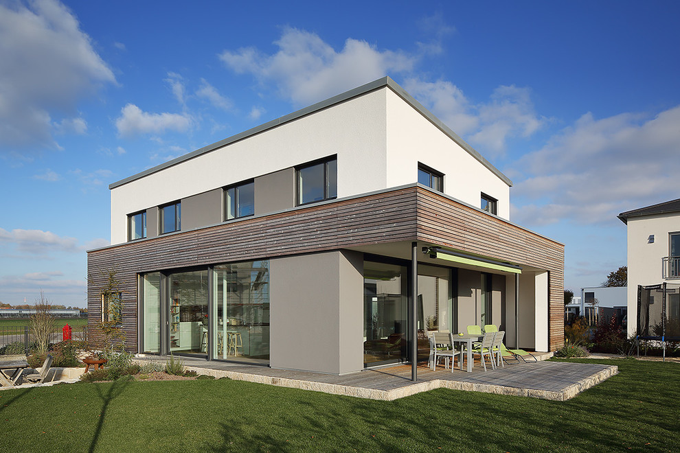Diseño de fachada de casa blanca contemporánea de tamaño medio de dos plantas con revestimientos combinados y tejado plano