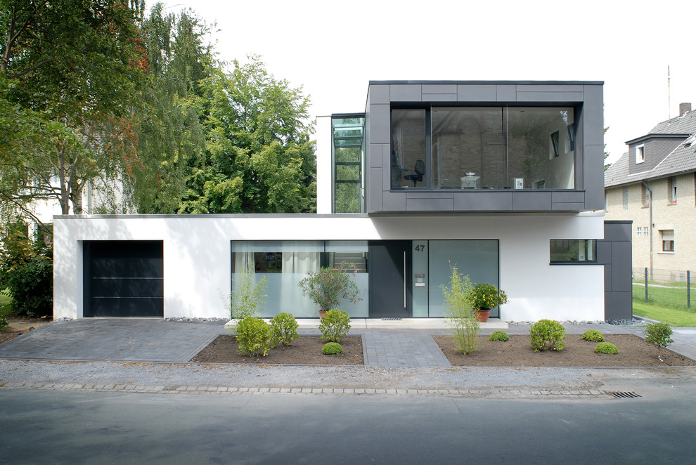 Mittelgroßes Modernes Einfamilienhaus mit Flachdach, Mix-Fassade und weißer Fassadenfarbe in Sonstige