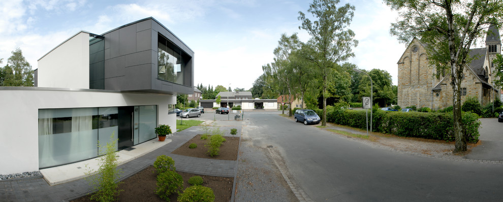 Mittelgroßes Modernes Einfamilienhaus mit Mix-Fassade, weißer Fassadenfarbe und Flachdach in Sonstige