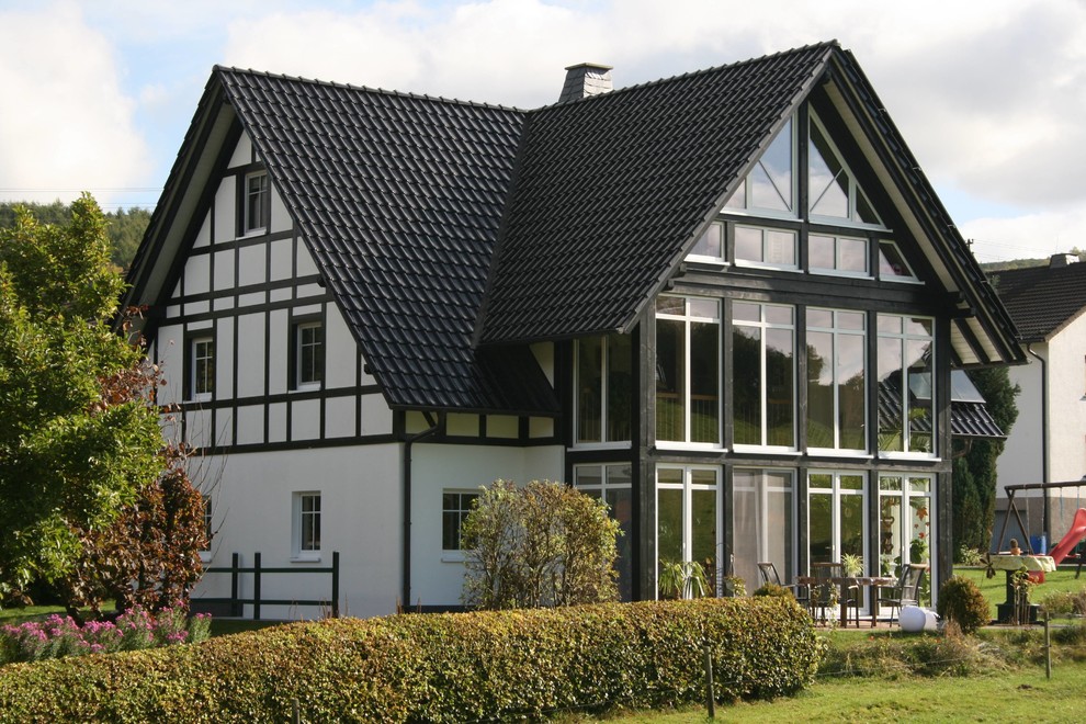 Großes, Dreistöckiges Uriges Einfamilienhaus mit Mix-Fassade, weißer Fassadenfarbe, Satteldach und Ziegeldach in Sonstige