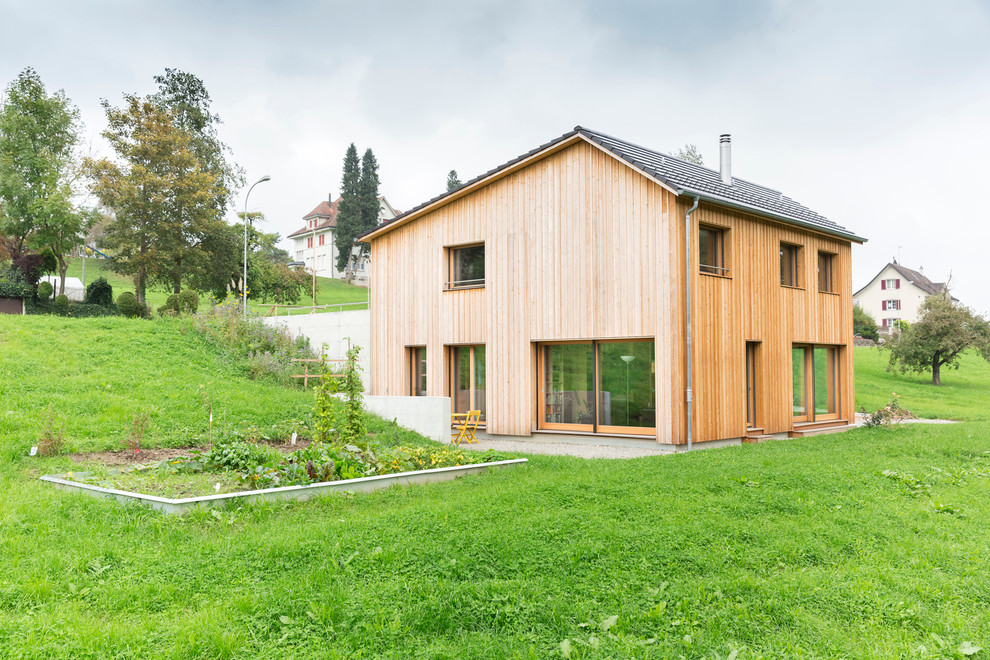 Cette photo montre une façade de maison marron tendance en bois à un étage et de taille moyenne avec un toit à deux pans.