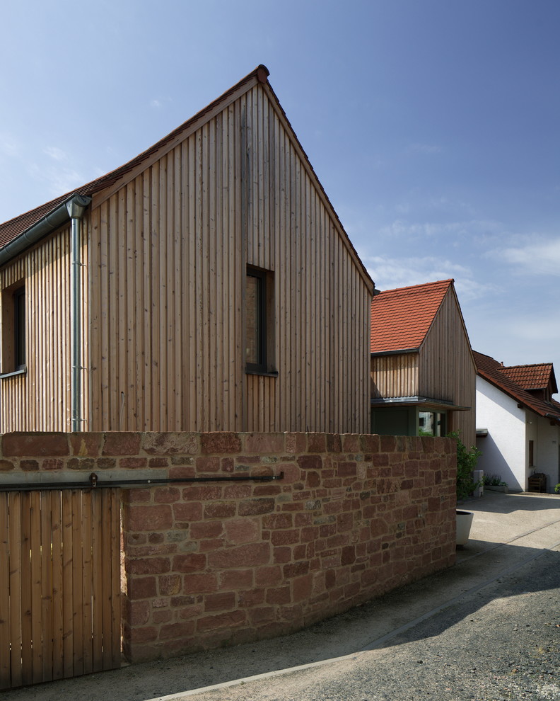 Exemple d'une façade de maison marron scandinave en bois de taille moyenne et à un étage avec un toit à deux pans et un toit en shingle.