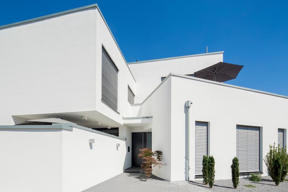 Geräumiges, Zweistöckiges Modernes Einfamilienhaus mit Putzfassade, weißer Fassadenfarbe und Flachdach in Düsseldorf