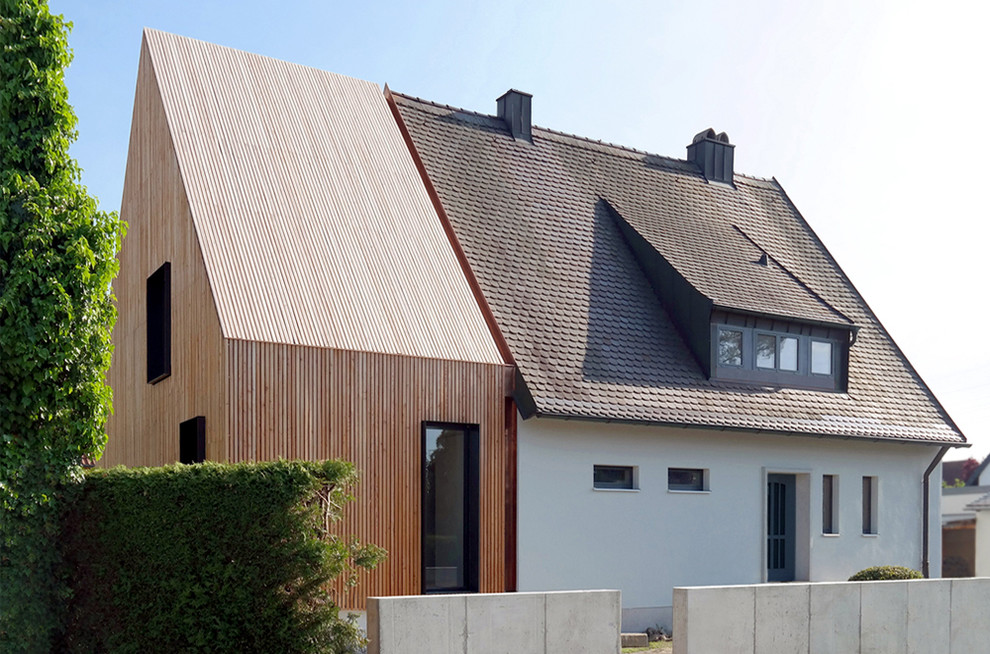 Esempio della facciata di una casa scandinava a un piano di medie dimensioni con rivestimento in legno e tetto a capanna