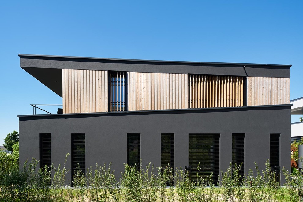 Einstöckige Moderne Holzfassade Haus mit schwarzer Fassadenfarbe und Flachdach in Berlin