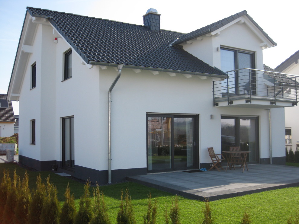 Exemple d'une façade de maison blanche chic de taille moyenne et de plain-pied avec un toit à deux pans.