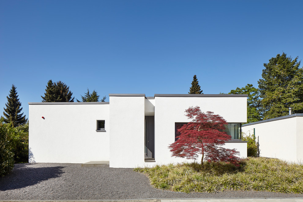 Idee per la villa piccola bianca moderna a un piano con rivestimento in stucco e tetto piano