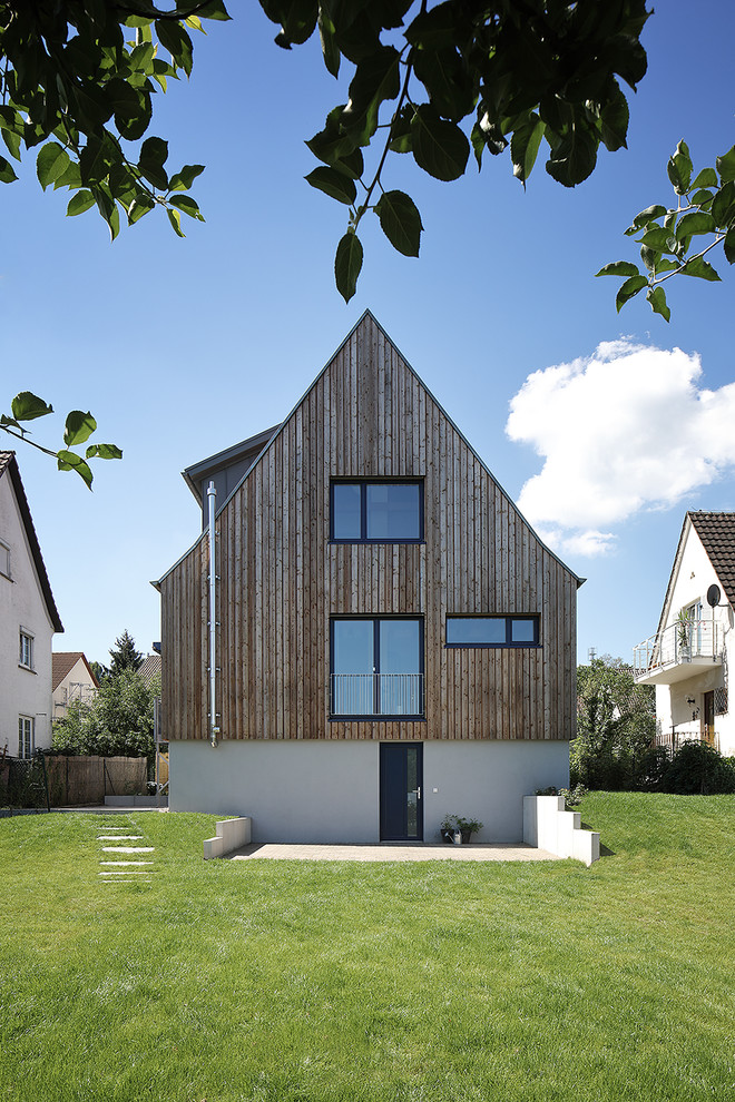 Dreistöckiges, Mittelgroßes Modernes Einfamilienhaus mit Mix-Fassade, beiger Fassadenfarbe und Satteldach