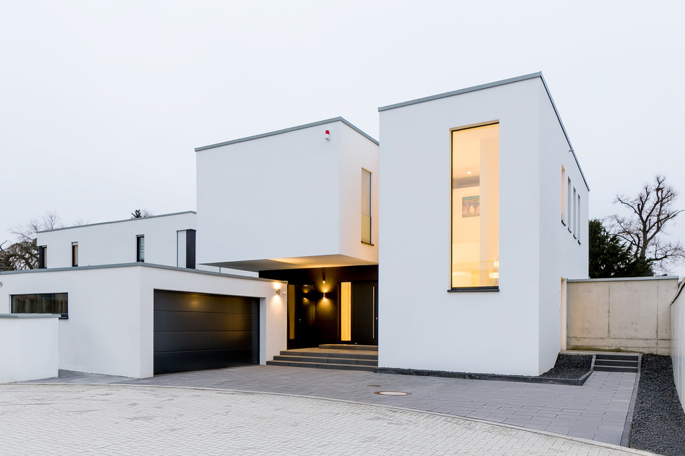 Inspiration for a contemporary white two-story stucco flat roof remodel in Dusseldorf