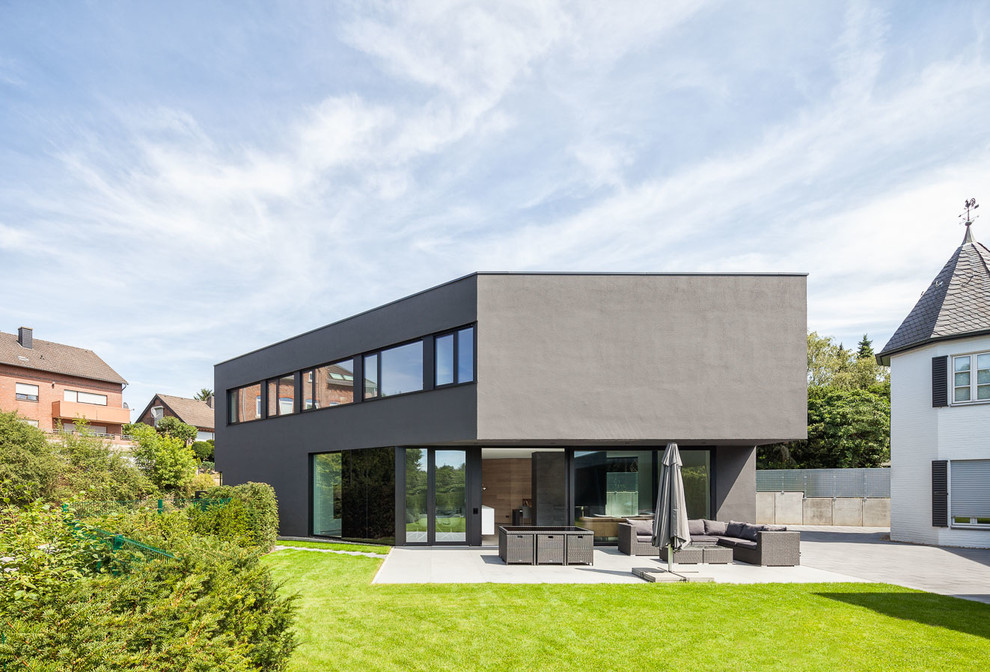 Mittelgroßes, Zweistöckiges Modernes Haus mit schwarzer Fassadenfarbe und Flachdach in Köln