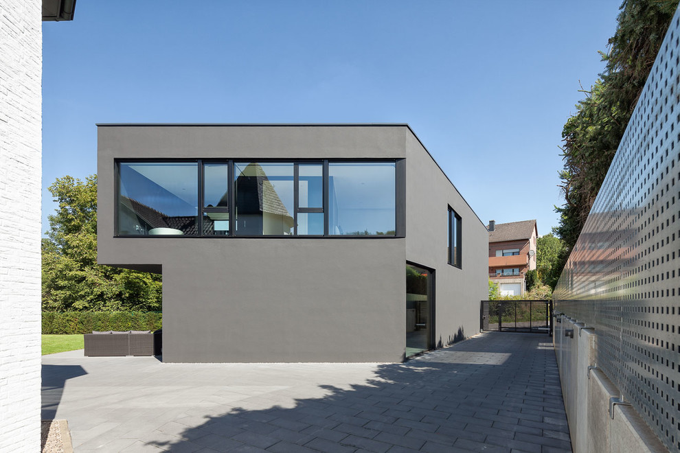 Mittelgroßes, Zweistöckiges Modernes Haus mit Flachdach und grauer Fassadenfarbe in Köln
