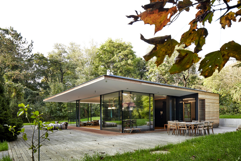 Inspiration för mellanstora moderna bruna hus, med allt i ett plan och platt tak