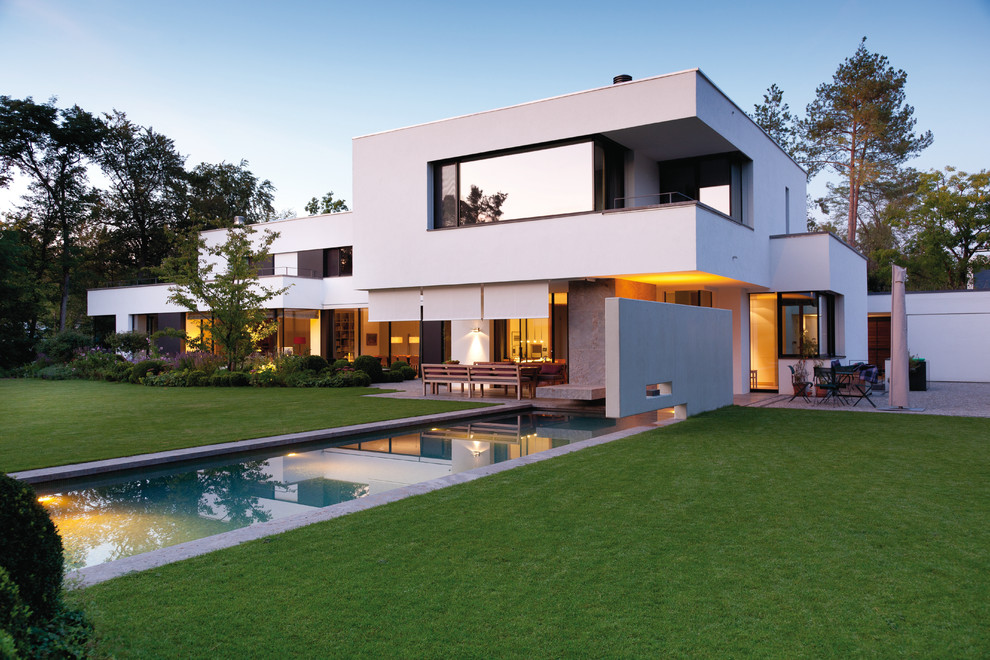 Стильный дизайн: белый, большой, двухэтажный дом в стиле модернизм с комбинированной облицовкой и плоской крышей - последний тренд