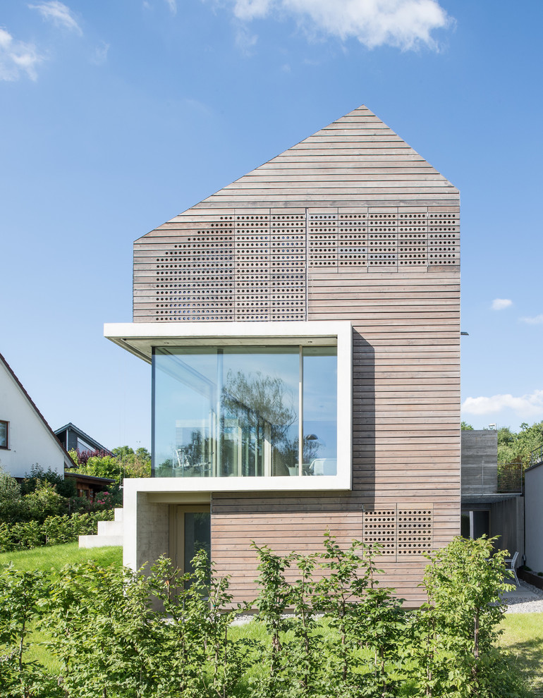 Réalisation d'une façade de maison marron minimaliste en bois de taille moyenne et à deux étages et plus avec un toit à deux pans.
