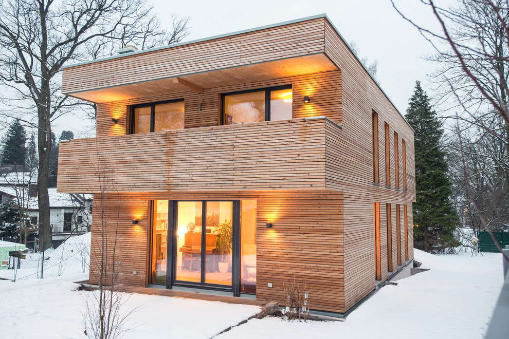 Medium sized and brown contemporary two floor house exterior in Nuremberg with wood cladding and a flat roof.