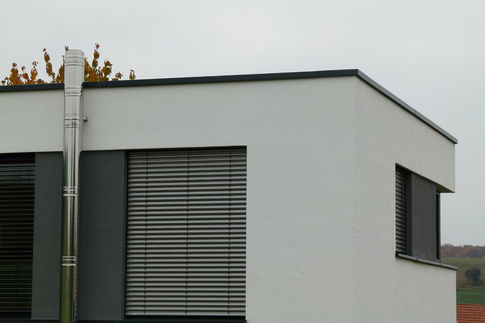 Diseño de fachada de casa blanca contemporánea grande de dos plantas con revestimiento de madera y tejado plano