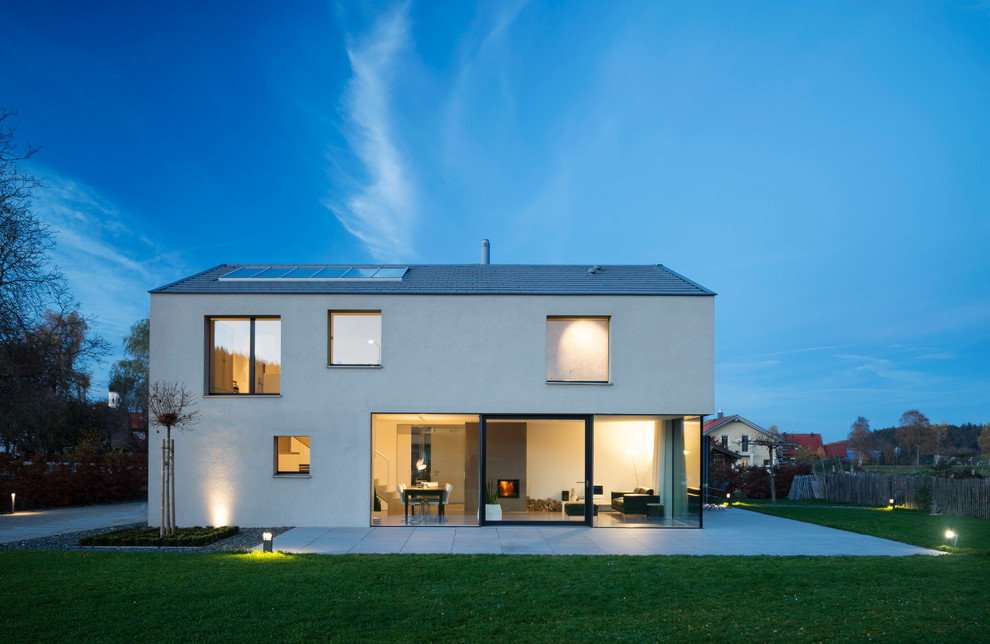 Идея дизайна: одноэтажный, белый дом среднего размера в стиле модернизм с облицовкой из цементной штукатурки и односкатной крышей