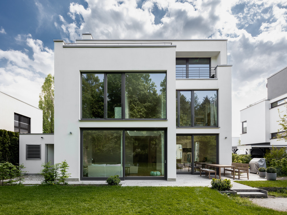 Идея дизайна: трехэтажный, белый частный загородный дом среднего размера в современном стиле с облицовкой из цементной штукатурки и плоской крышей