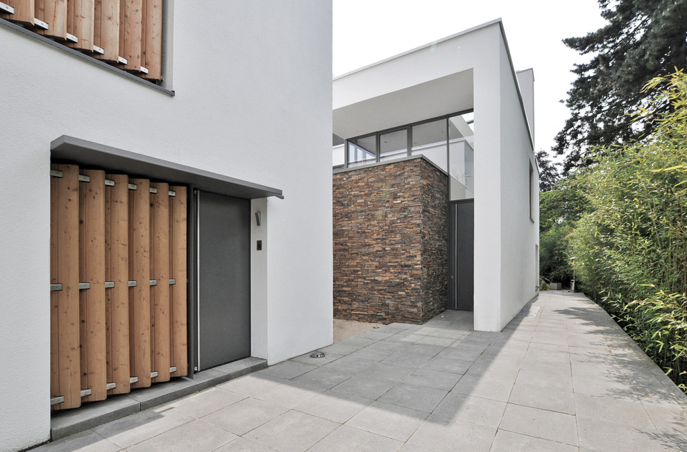This is an example of an expansive and white contemporary two floor house exterior in Dusseldorf with a flat roof.