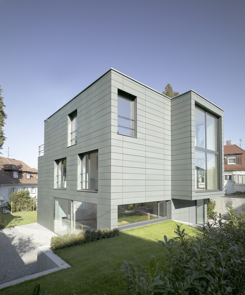 Large and gey contemporary house exterior in Stuttgart with three floors and a flat roof.