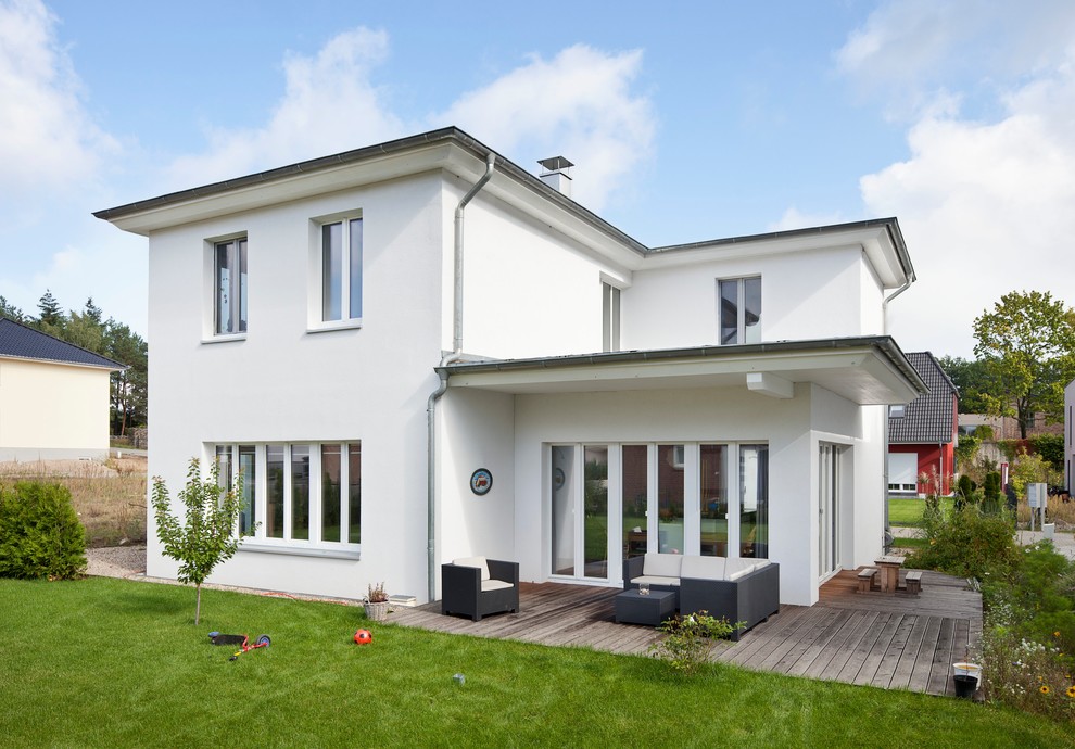 Mittelgroßes, Zweistöckiges Modernes Einfamilienhaus mit weißer Fassadenfarbe und Flachdach in Berlin