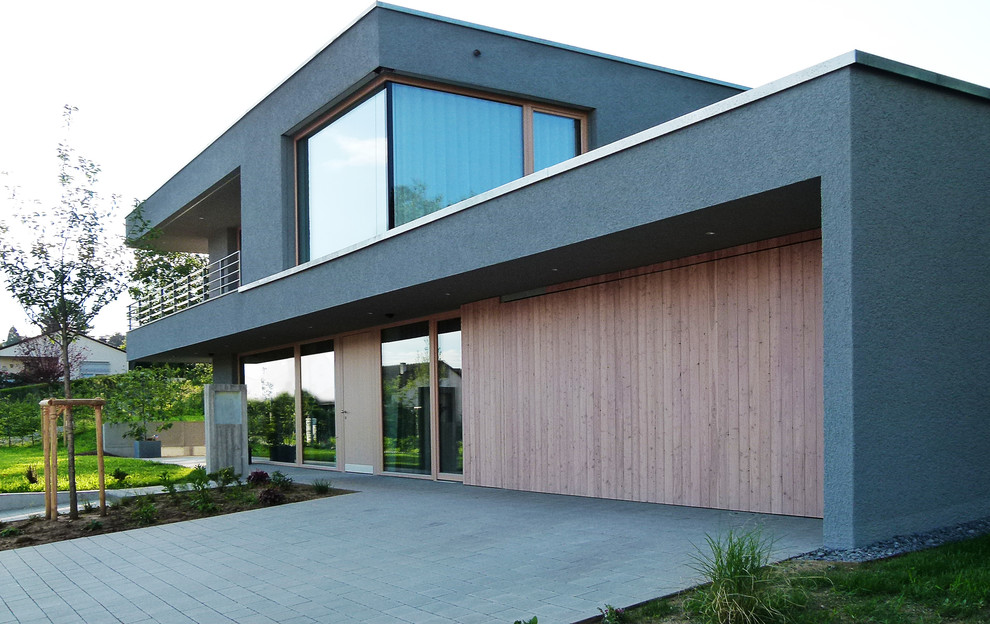 Mittelgroßes, Zweistöckiges Modernes Einfamilienhaus mit Mix-Fassade, grauer Fassadenfarbe und Flachdach in Stuttgart