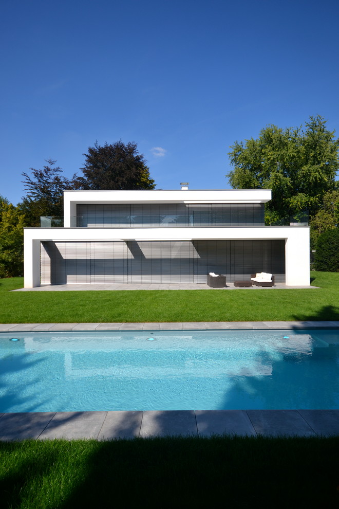 Modelo de fachada blanca minimalista de tamaño medio de una planta con revestimiento de estuco y tejado plano