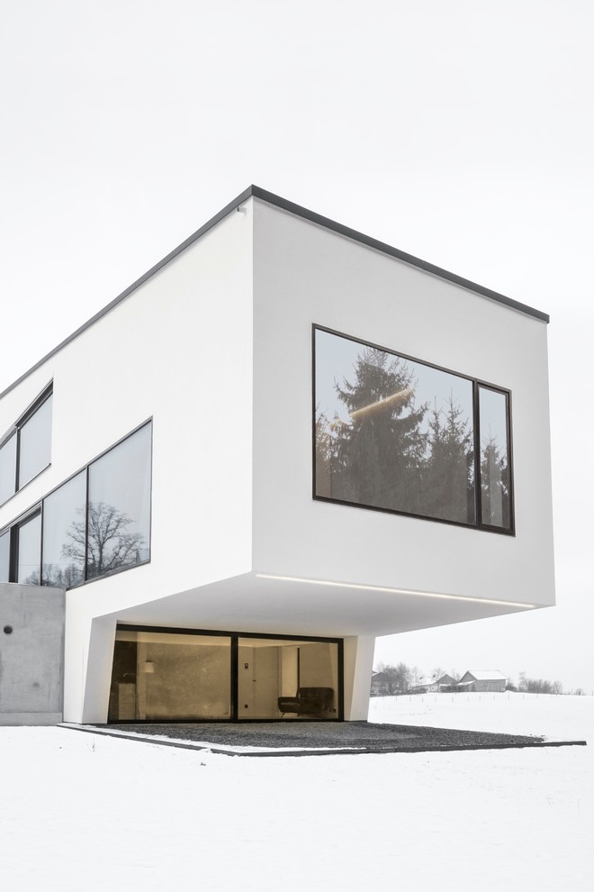 Large minimalist white three-story stucco exterior home photo in Other