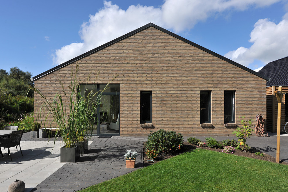 Diseño de fachada marrón actual de tamaño medio de una planta con revestimiento de ladrillo y tejado a dos aguas