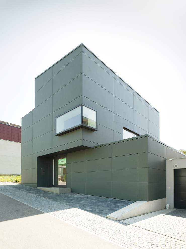 Esempio della facciata di una casa grigia contemporanea a tre piani di medie dimensioni con tetto piano