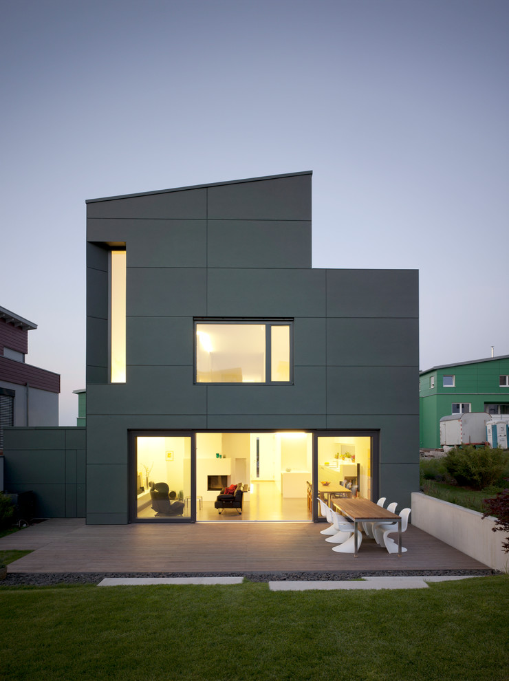 Пример оригинального дизайна: двухэтажный, кирпичный, серый дом среднего размера в современном стиле с односкатной крышей