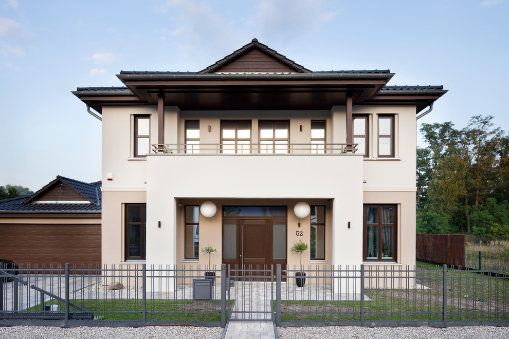 Inspiration pour une grande façade de maison marron traditionnelle à un étage avec un toit à quatre pans.
