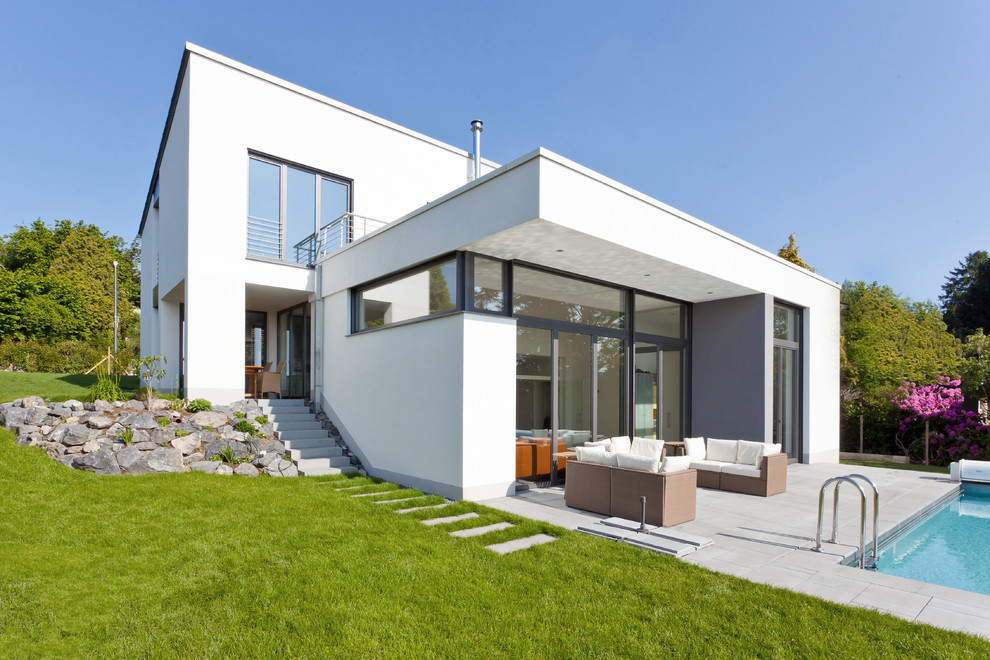 Свежая идея для дизайна: двухэтажный, белый, большой дом в современном стиле с плоской крышей - отличное фото интерьера