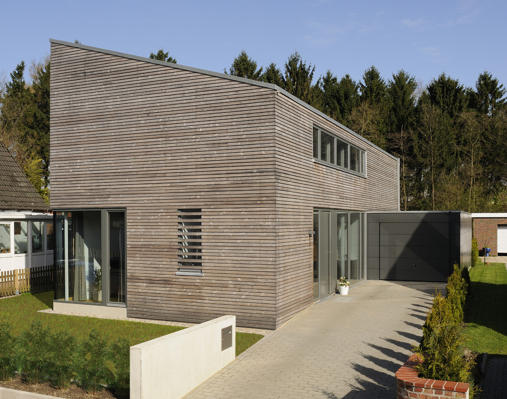 Стильный дизайн: двухэтажный, деревянный, коричневый дом среднего размера в современном стиле с односкатной крышей - последний тренд