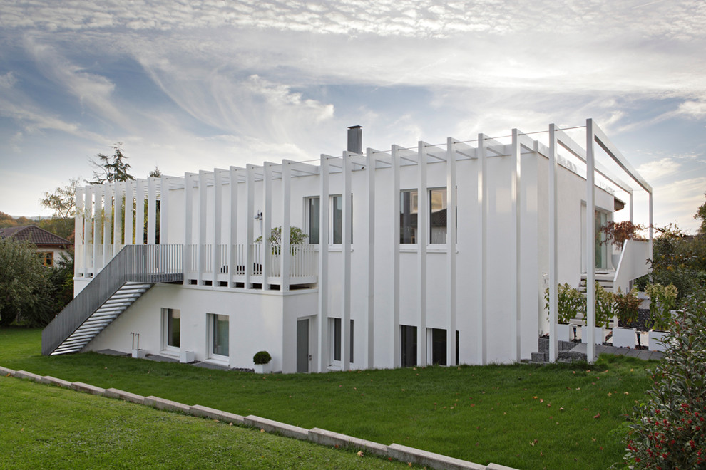 Пример оригинального дизайна: белый, двухэтажный дом среднего размера в современном стиле с плоской крышей