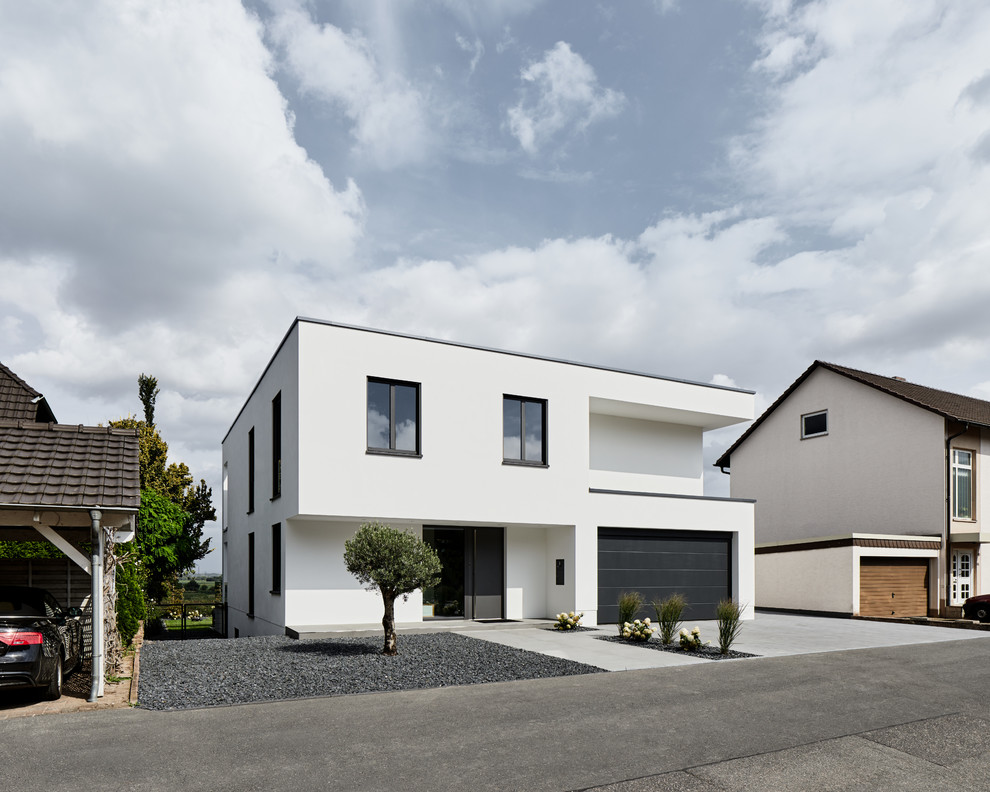 Design ideas for a small and white contemporary two floor render detached house in Cologne with a flat roof.