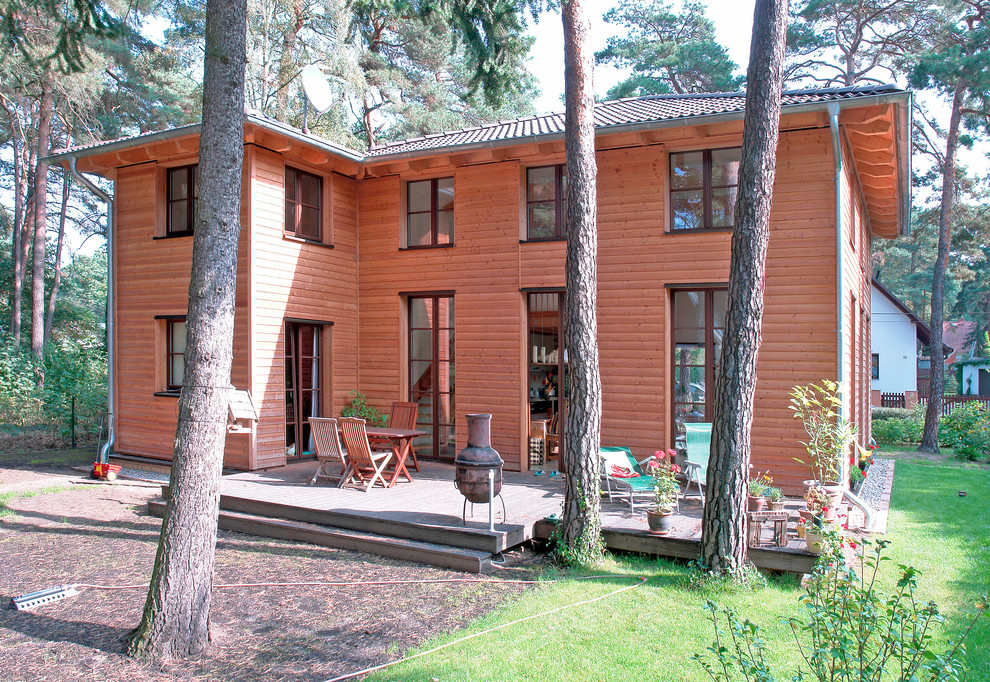 Diseño de fachada de casa marrón actual de dos plantas con revestimiento de madera y tejado de teja de barro